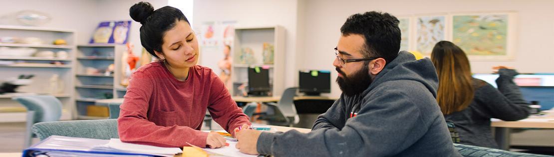 A tutor working with a student at a PCC library.